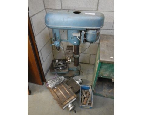 A large pedestal drill and tools
