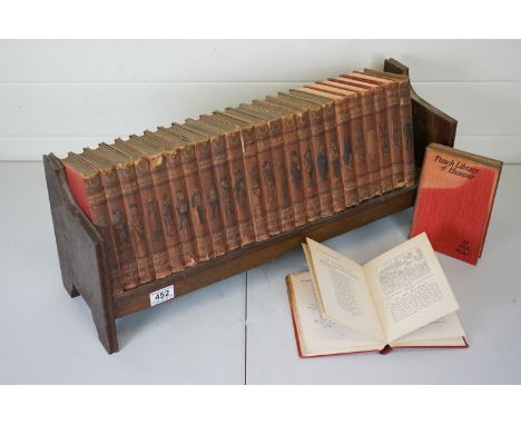 A collection of twenty four Mr Punch on Tour punch library of humour bound books on wooden fitted shelf 