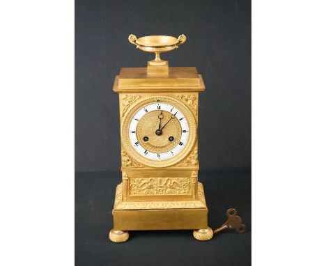 French Gilt Brass Mantle Clock with urn finial, 8 day movement, the white enamel chapter ring with Roman numerals, the gilt c