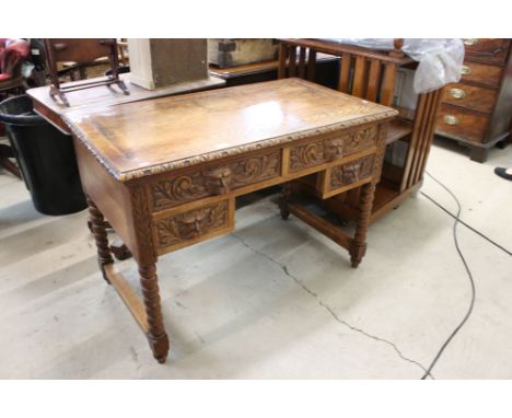 Early 20th century Jacobean Revival Oak Desk, the four drawers heavily carved with lion masks and raised on bobbin legs, 107c