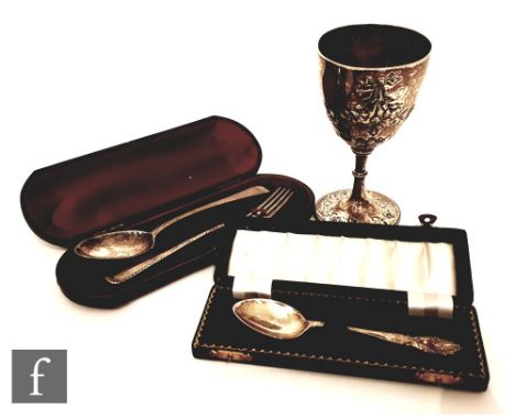 A hallmarked silver Victorian small goblet with embossed and engraved floral decoration, London 1869, with a cased fork and s