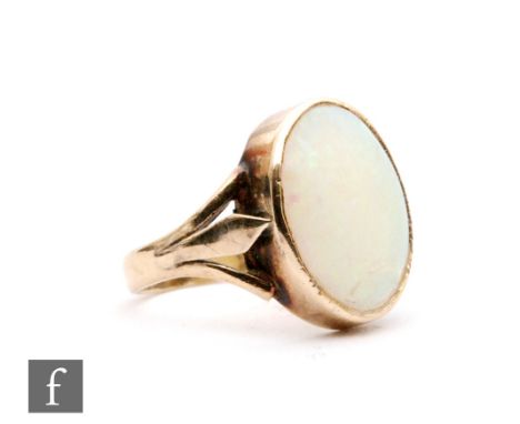 A mid 20th Century 9ct opal ring, single oval cabochon collar set stone to split shoulders, weight 3g, ring size G. 