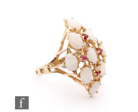 A 9ct hallmarked opal and ruby marquise shaped cluster ring with nine oval opals spaced by four claw set rubies, ring size Q.