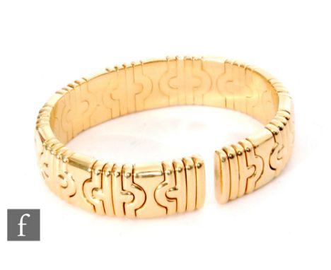 An 18ct Bvlgari sprung torque bangle with inverted hour glass and ribbed decoration, weight 82g, stamped to one end. 