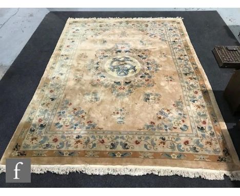 A large 20th Century Chinese carpet, all over floral decoration on a beige ground within a running floral border, 370cm x 277