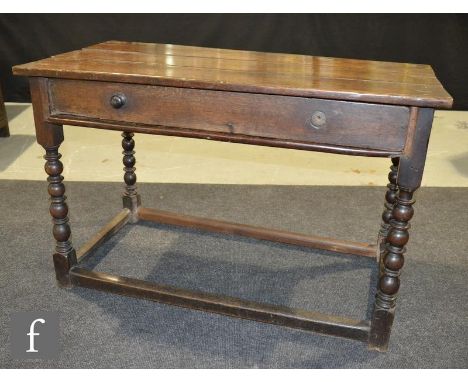 An 18th Century oak plank top side table on bobbin turned legs united by rail stretchers, height 74cm x depth 56cm x width 11