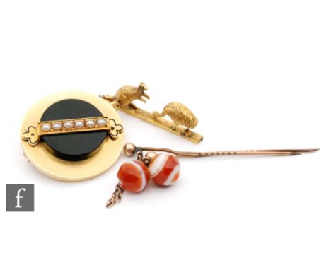 A 15ct circular memorial brooch with a central row of pearls, a similar brooch with a kangaroo and ostrich, A/F, with an agat