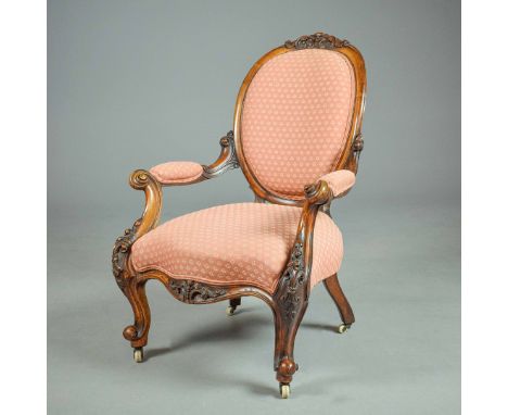 MID VICTORIAN ARMCHAIR. walnut in patterned terracotta fabric on ceramic castors, 98cm H x 69cm W x 83cm D.