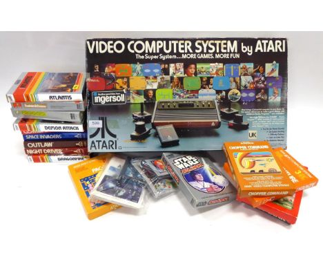 Atari Video Computer System CX-2000 together with a box of game cartridges including Pacman, Asteroids, Chopper Command, Frog