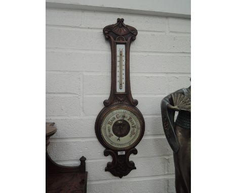 An Edwardian oak case banjo aneroid barometer having thermometer scale