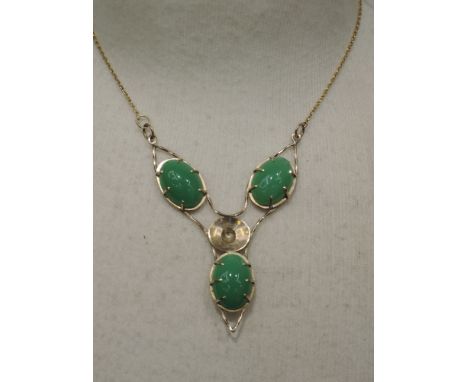 A jade pendant formed out of three oval cabouchon stones in a 9ct gold stylised mount on a fixed chain,  designed by Steve Ba