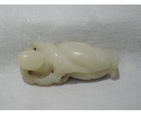 A carved hard stone brooch, possibly white jade modelled as an Oriental gent with white metal fittings