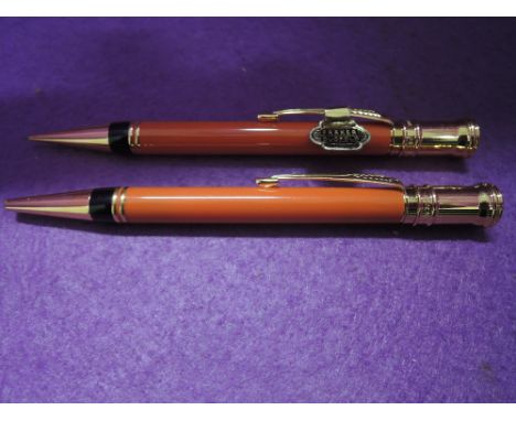 Two Parker Duofold.A propelling pencil and rollerball pen with two rings to barrel and Duofold crest to top, in orange one wi