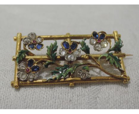 A French 18ct gold brooch modelled as flowers on a trellis having sapphire, diamond and ruby set petals and enamelled leaves,