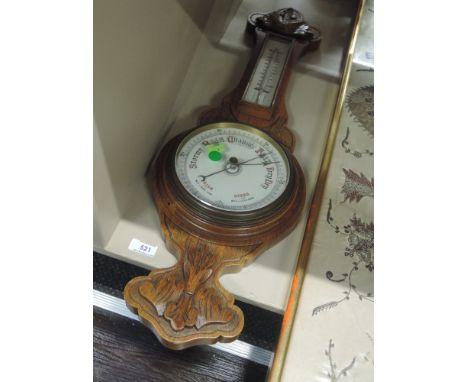 An Edwardian oak aneroid banjo barometer having carved decoration and thermometer scale