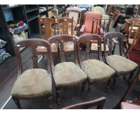 A set of four late Victorian mahogany salon dining chairs having incised sweep backs, with moquette seats and turned legs