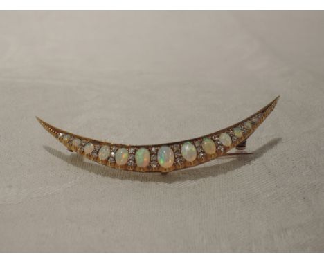 An opal and diamond crescent brooch set with  thirteen graduated opals interspersed by rows of diamond chips in a yellow meta