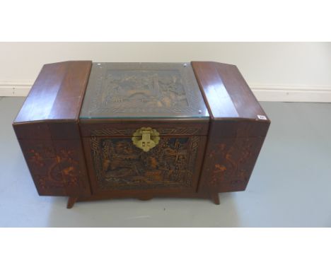 An Oriental camphor wood trunk with carved decoration to exterior, hinged lid opening to reveal sliding drawer - 91cm x 47cm 