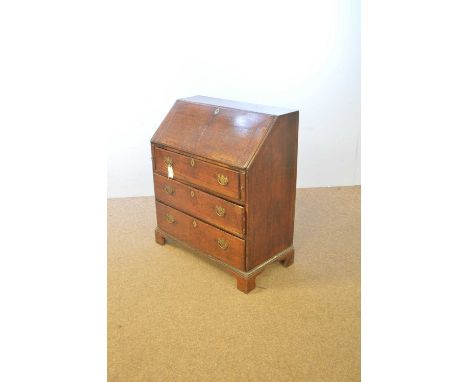 A George III oak bureau, the rectangular top above a fall-front enclosing an arrangement of drawers and pigeon holes, raised 