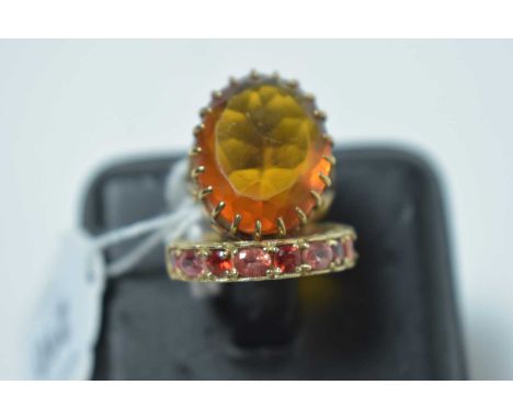 A red and pink gemstone eternity ring, in yellow metal mount, stamped '9K'; and an orange paste ring on yellow metal shank, s