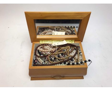 A contemporary jewellery box containing a large quantity of faux pearl and pearl necklaces, including a black pearl bracelet 