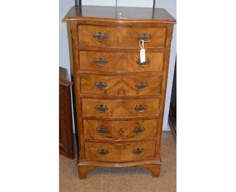 A 20th Century burr walnut veneered chest of drawers by W Harker of Newcastle, the serpentine top above an arrangement of six