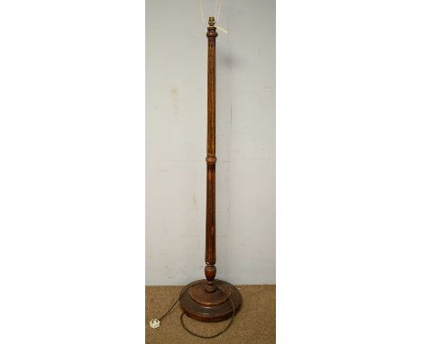 An early 20th Century stained beech standard lamp, with central tapering and fluted column above a circular dished base, 173c