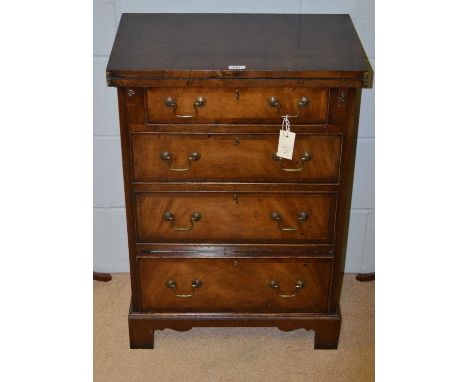 A 20th Century mahogany bachelor's chest, in the Georgian style, the rectangular hinged top enclosing a plain surface above a