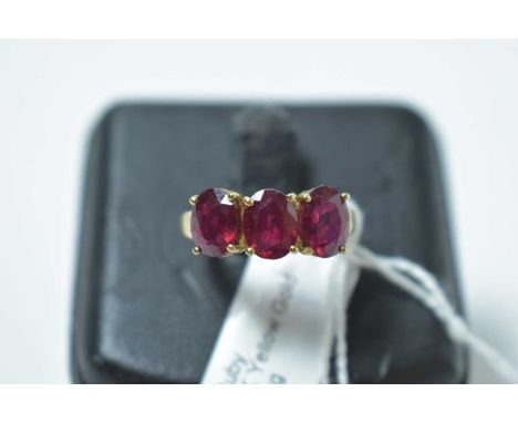 A contemporary 9ct gold and ruby three stone ring, 3.5g