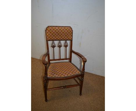 An Art Nouveau style occasional chair, the shaped padded back with stylized tulip uprights, scrolled arms above a padded seat