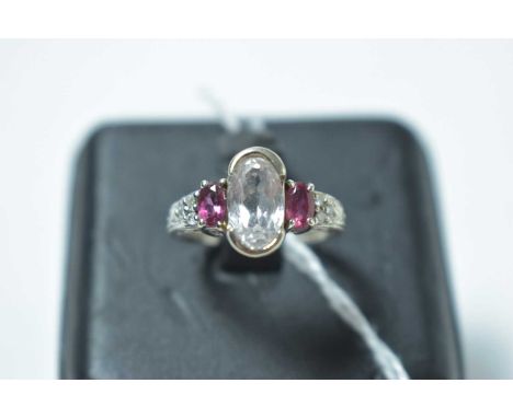 A contemporary 14ct white gold, white sapphire, ruby and diamond ring, of Victorian influence, having a central oval cut sapp