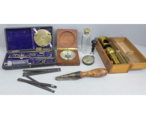 A collection of instruments/tools; a brass microscope, boxed, a leather working tool, two compasses, one cased and one marked
