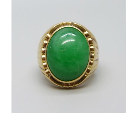 A yellow metal ring set with a cabochon jade stone, 12.5g, M