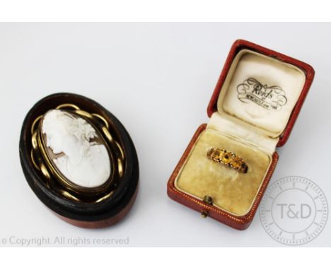 A citrine set ring, the five circular citrine's within yellow metal setting stamped '15ct', with an oval carved shell cameo b