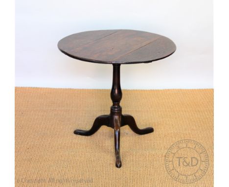 A George III circular oak occasional table, with three plank tilt top on a turned column and tripod base, 65cm H x 69cm W