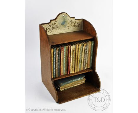 An early 20th century 'Peter Rabbits Book Shelf', the oak shelf with original label, to include a possible first trade editio