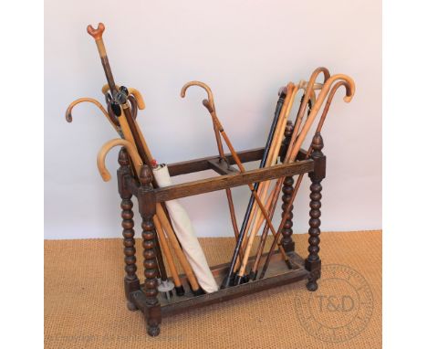 A Victorian carved oak oak stick stand, two section, on bobbin turned legs, 68cm H x 77cm W x 25cm D, sold with a selection o