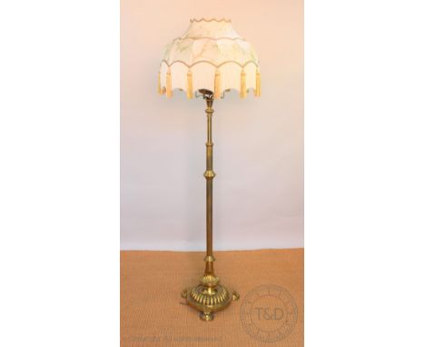 A late Victorian brass oil standard lamp converted for electricity, with fluted column, on gadooned domed base and circular f
