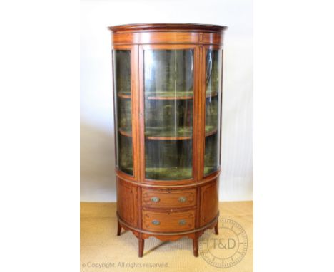 An Edwardian inlaid satinwood demi-lune display cabinet, with door enclosing three shelves, over two drawers, on splayed legs