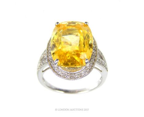 A spectacular, 18 ct white gold, yellow topaz and diamond dress ring featuring an extremely large, oval- shaped, faceted, yel