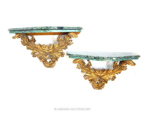 A pair of 19th-20th century carved giltwood acanthus console brackets, each surmounted by a serpentine fronted panel of green