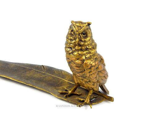 A gilt bronzed metal owl on quill style inkwell stand; 34cm long.