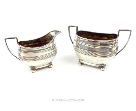 A hallmarked sterling silver milk jug and matching twin handled sugar bowl, assayed in Sheffield in 1914, made by Harrison Br