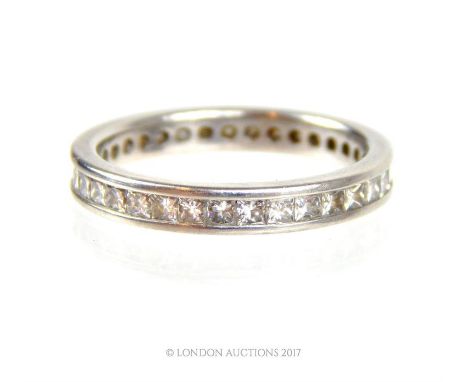 A boxed, platinum and diamond set eternity band, channel- set with approximately thirty-five, square-shaped, brilliant cut di