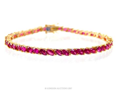 Tested as 14 ct yellow gold, natural, (treated), ruby tennis bracelet composed of fifty-one, double-claw set, marquise-shaped