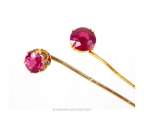 Two 18ct gold and ruby stick pins, each having a single round cut ruby, claw set in a plain gold mount, together with a perio