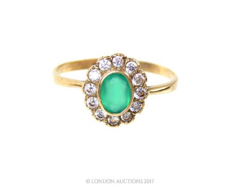 A 1930's, 9 ct yellow gold, natural emerald and diamond cluster ring, composed of a central, oval-shaped, faceted stone (6 x 