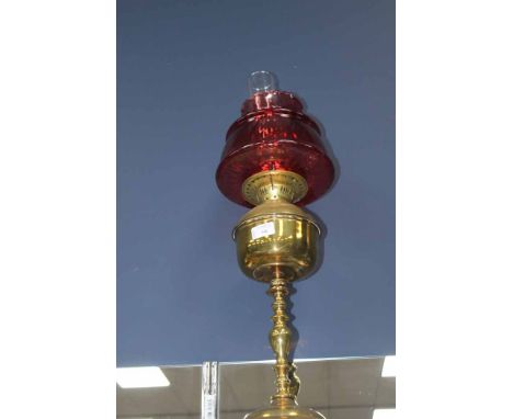 BRASS PARAFFIN LAMP 
with a cranberry glass shade