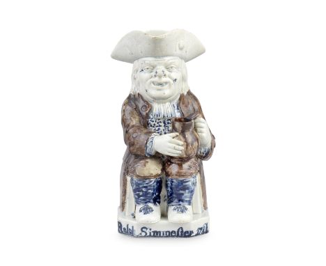 A rare dated pearlware Toby jug, circa 1784Of traditional form, seated and grasping a jug with both hands, a pipe resting on 