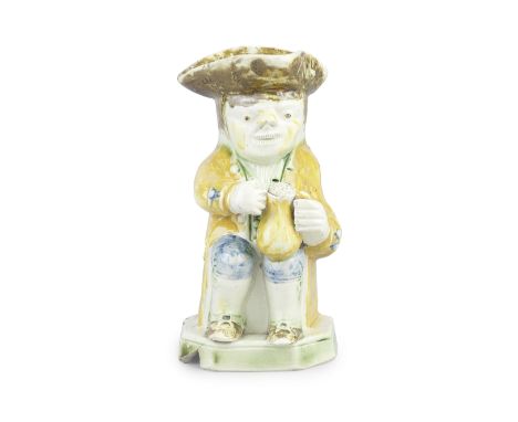 A small creamware 'Askew' Toby jug, circa 1800-10Seated and holding a foaming jug in both hands, wearing a bright yellow coat